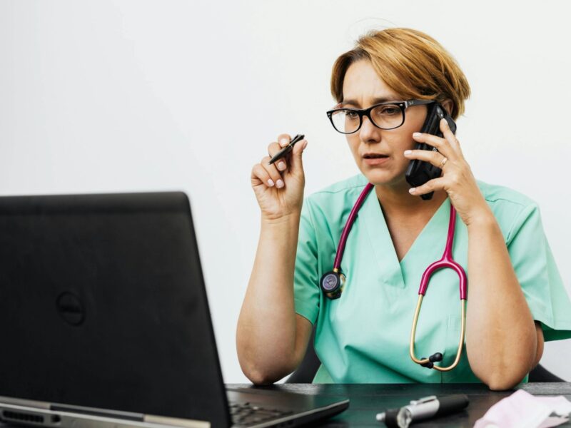 Portrait of Doctor with Stethoscope Working on Laptop
