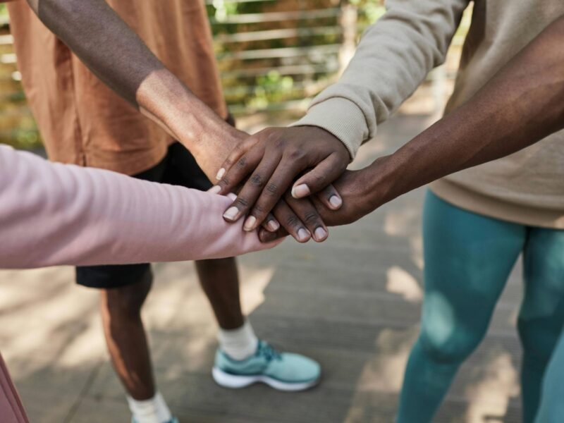 Group of People Standing with Their Hands in a Huddle